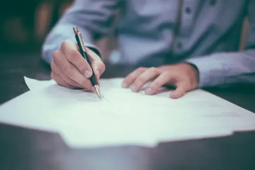Persona firmando documentación para solicitar una hipoteca